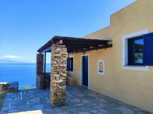 una casa con un patio de piedra junto al océano en Home in Kea, en Ioulida