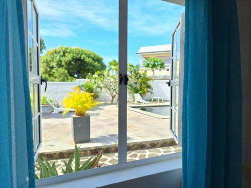 an open window with a view of a patio at Le Beau Manguier Residence Bed & Breakfast in Pereybere