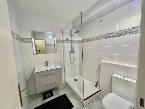 une salle de bain blanche avec douche et toilettes dans l'établissement Appartement 1 Chambre Petit Juas, à Cannes