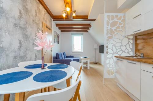 a kitchen and dining room with a white table and chairs at Apartament Willa Finezja in Kąty Rybackie