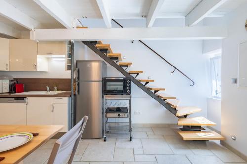 une cuisine avec un escalier en colimaçon et une table dans l'établissement La Paillote de JCC - 500 mètres de la plage, à Martigues