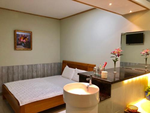 a bedroom with a bed with a sink and a mirror at Khang Bảo Viên in Củ Chi