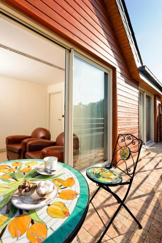 a table and chairs on a patio with a glass door at Logis L'Auberge - Maison Glenn Anna in Sainte Anne d'Auray 
