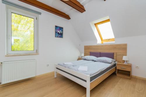 a white bedroom with a bed and a window at Apartament in Kąty Rybackie