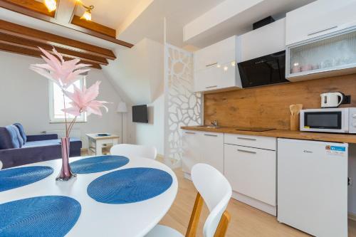 a kitchen and dining room with a table and chairs at Apartament in Kąty Rybackie