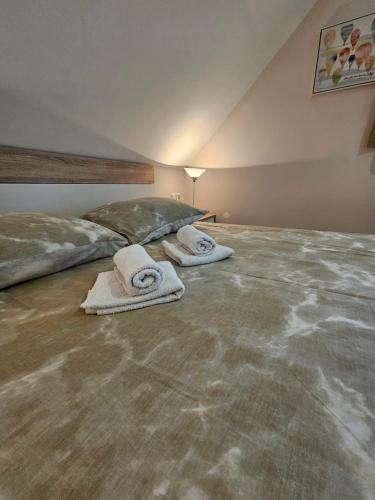 - une chambre avec un lit et des serviettes à l'étage dans l'établissement Apartments Luka, à Rakovica