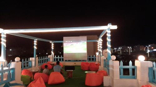 une scène avec des gens qui regardent un match de football sur un écran dans l'établissement القاهره, à Ḩulwān