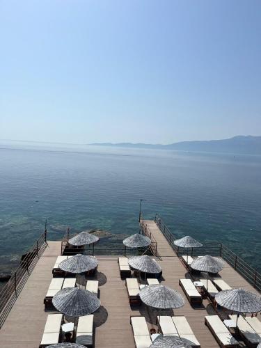 un grupo de sillas y sombrillas en un muelle en Veranda Glamping, en Ayvacık