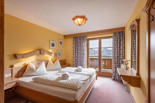 sypialnia z dużym łóżkiem i oknem w obiekcie Hochfeldalm w mieście Sankt Johann in Tirol