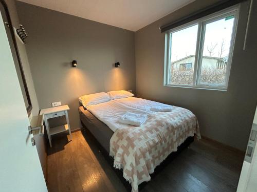 Habitación pequeña con cama y ventana en Apartment Skógafoss, en Skogar