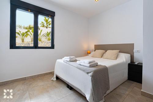 - une chambre blanche avec un lit et une fenêtre dans l'établissement Villa Nautilus by Abahana Villas, à Benissa