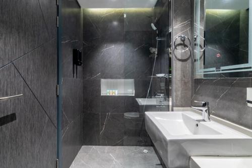 a bathroom with a sink and a shower at The Smart Concierge - Samana Hills in Dubai
