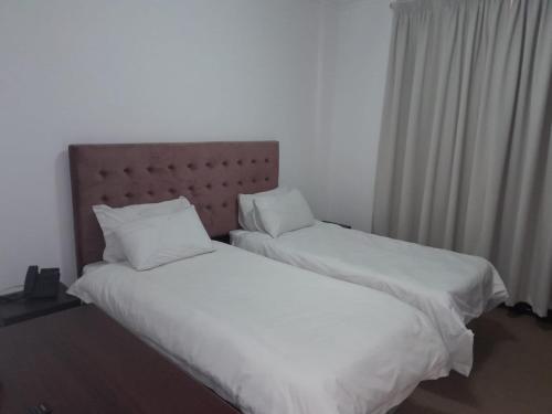 two beds sitting next to each other in a bedroom at Sapphire Hotel Halevy Heritage in Bloemfontein