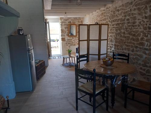 une cuisine et une salle à manger avec une table et des chaises dans l'établissement Gite L'hirondelle en Auvergne, à Champs