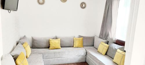 ein Wohnzimmer mit einem grauen Sofa und gelben Kissen in der Unterkunft SOL Y MAR in Empuriabrava