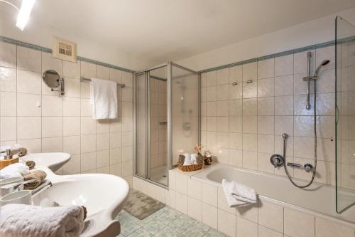 y baño con bañera, lavamanos y ducha. en Hochfeldalm en Sankt Johann in Tirol