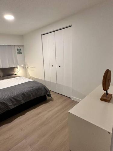 a bedroom with a bed and a white cabinet at Adorable Main Street Haven in Vancouver