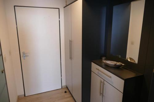 a bathroom with a white door and a sink at Ferienwohnungen Bayerwaldblick im Ferienpark Geyersberg in Freyung