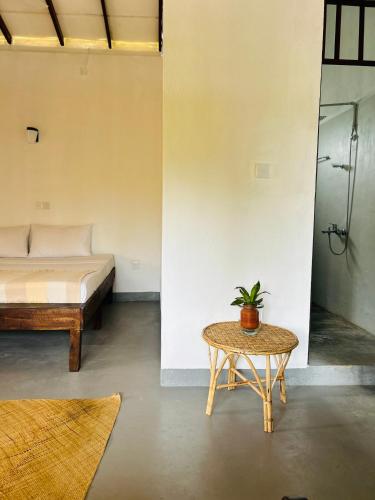 a room with a bed and a table with a potted plant at One Bhakthi in Ahangama