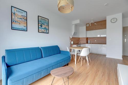 a living room with a blue couch and a table at GRANO FLATS - Sobieszewo - Baltic Porto in Gdańsk