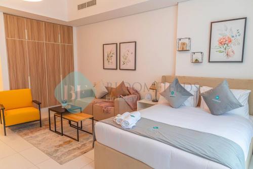 Habitación de hotel con cama y silla en Spacious Studio In Thalassa en Abu Dabi