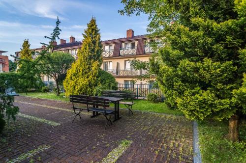 a park with a bench in front of a building at Hotel *** NAT Kołobrzeg in Kołobrzeg