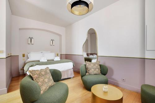 une chambre d'hôtel avec un lit et deux chaises dans l'établissement Pick A Flat's Apartment in Place Vendôme - Rue Duphot, à Paris