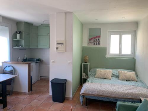 um pequeno quarto com uma cama e uma cozinha em Studio cosy avec clim 33m2 em Aimargues