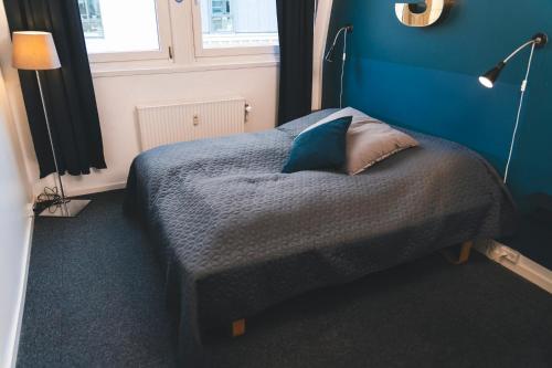 a bedroom with a bed with a blue wall at Danhostel Aarhus City in Aarhus