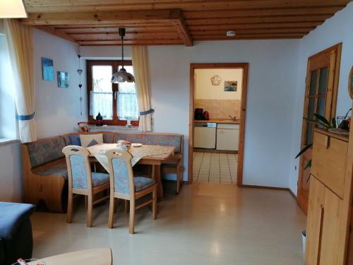 Apartment in Steingaden with terrace في شتاينغادن: مطبخ وغرفة طعام مع طاولة وكراسي