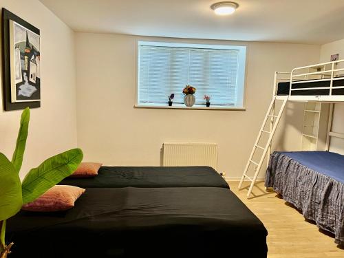 ein Schlafzimmer mit einem Etagenbett und einem Fenster in der Unterkunft 300 meter walk to LEGO HOUSE - 80m2 two bedroom apartment with garden in Billund