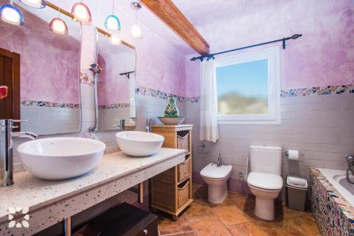 a pink bathroom with two sinks and a toilet at Villa Tuvalu by Abahana Luxe in Moraira
