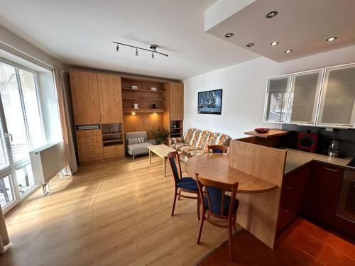 a kitchen and living room with a table and chairs at Vila Dům Evropa in Třeboň