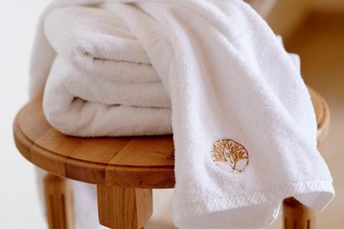 un mucchio di asciugamani poggiati su uno sgabello di legno di Chambre Flori - Lavy a Saint-Pierre-de-Côle