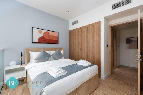 a bedroom with a large bed with a wooden headboard at Premium 1 Br Duplex In Rukan in Dubai