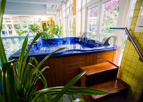 a blue tub in a bathroom with a potted plant at Hotel *** NAT Kołobrzeg in Kołobrzeg