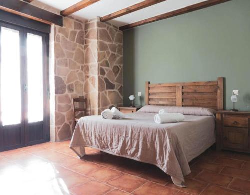 CardeñosaにあるCasa Rural El Caño Del Santoのベッドルーム1室(大型ベッド1台、タオル付)