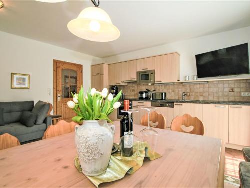 eine Küche mit einem Tisch und einer Blumenvase darauf in der Unterkunft Apartment Apartment Wallischer Johann by Interhome in Aschau