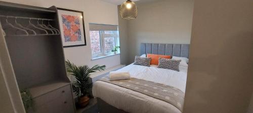 - une petite chambre avec un lit et des oreillers orange dans l'établissement 1 Bedroom Modern Living in The Old Bank House in Market Rasen, à Market Rasen