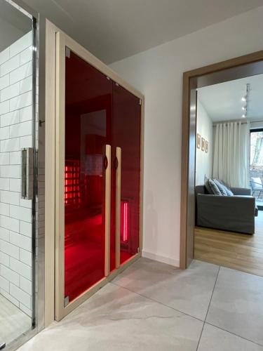 Habitación con una puerta de cristal que da a una sala de estar. en Apartament pod Wielką Sową, en Pieszyce