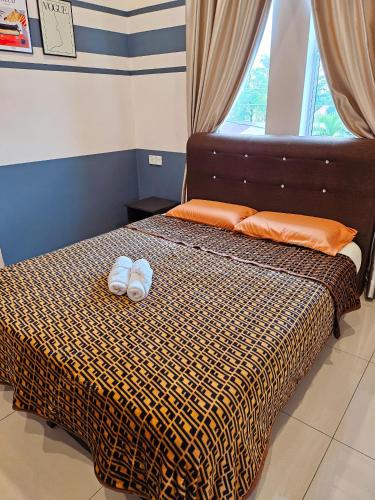 a bedroom with a bed with two towels on it at The Blue Guest House, WiFi, Free Parking, Aulong in Taiping