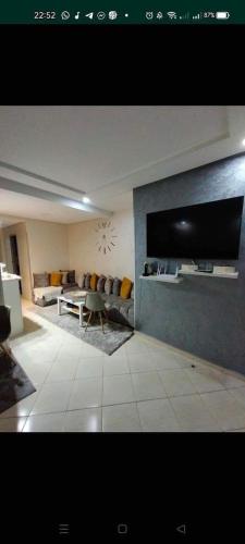 a living room with a couch and a tv at appartement résidence dchaira jadida in Dcheira El Jihadia