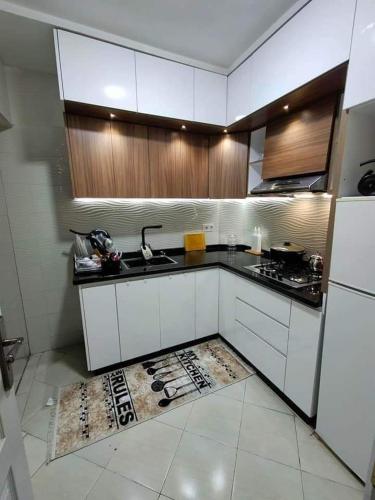 a kitchen with white cabinets and a sink and a stove at appartement résidence dchaira jadida in Dcheira El Jihadia