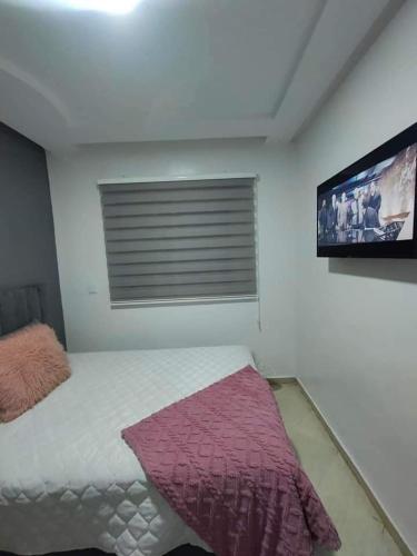 a bedroom with a bed and a flat screen tv at إقامة دشيرا الجديدة جهادية in Dcheira El Jihadia