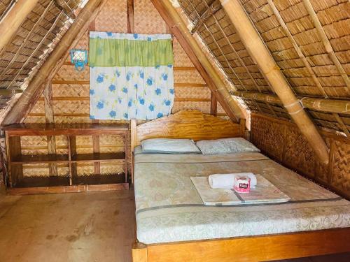 een kamer met een bed in een rietje bij Binucot Lodge in Romblon