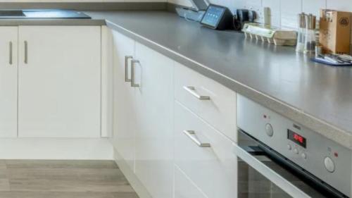 a kitchen with white cabinets and a counter top at Luxury Villas Kalafati Mikonos in Mýkonos City