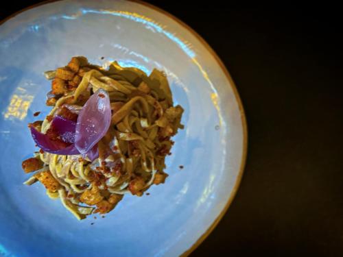 a white plate of food with noodles and vegetables at Podere Bellavista in San Gimignano