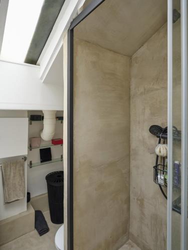 une salle de bain avec une porte coulissante en verre donnant sur une pièce dans l'établissement Atelier d'artiste en plein Paris, à Paris