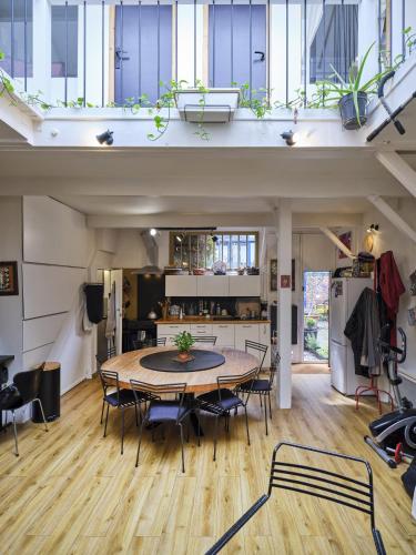 une salle à manger et une cuisine avec une table et des chaises dans l'établissement Atelier d'artiste en plein Paris, à Paris