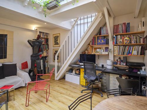 - un salon avec un bureau et un escalier dans l'établissement Atelier d'artiste en plein Paris, à Paris